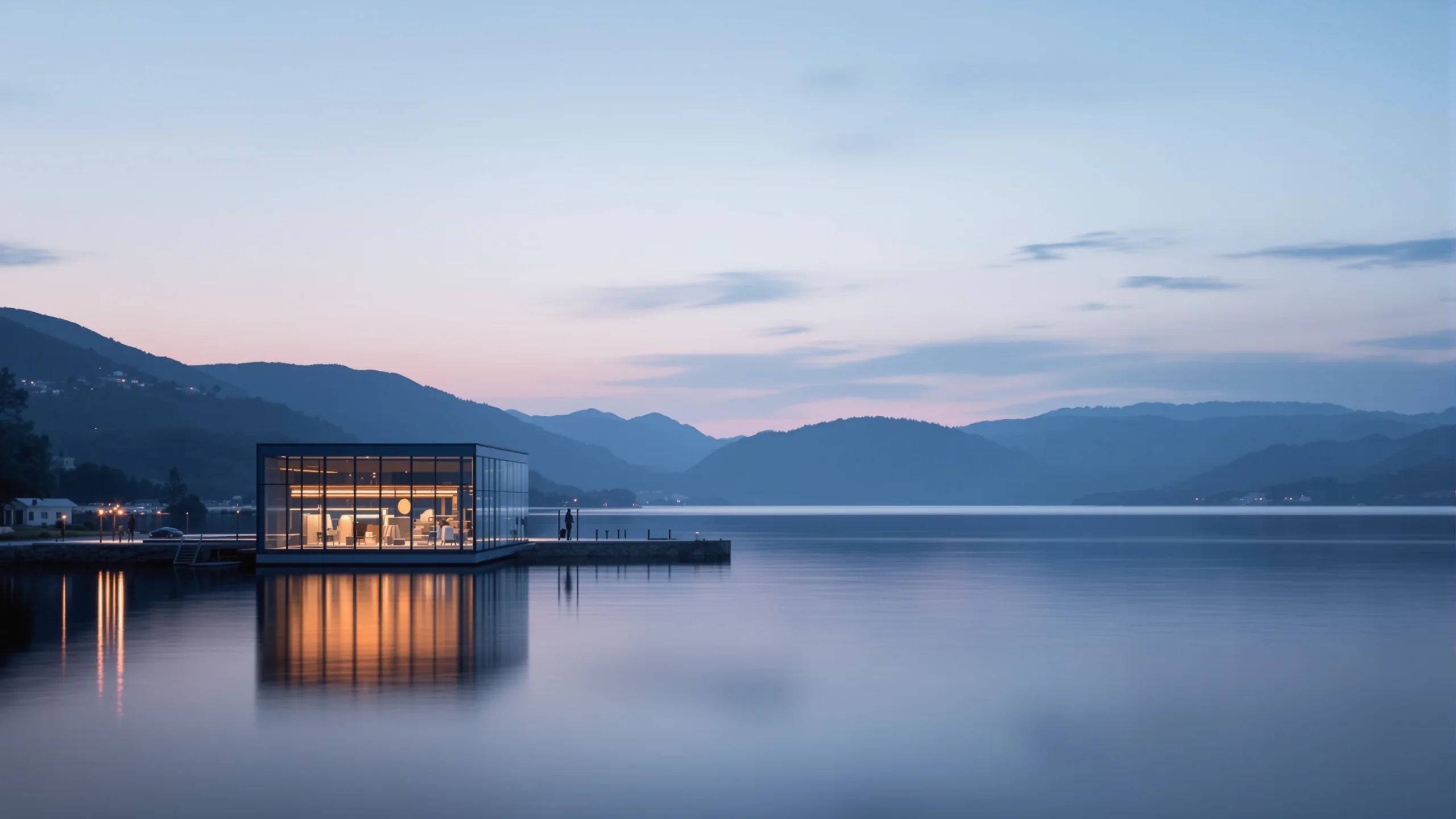 Beleuchteter Glaspavillon auf einem Steg am stillen See in der Abenddämmerung, dunkle Hügelketten dahinter