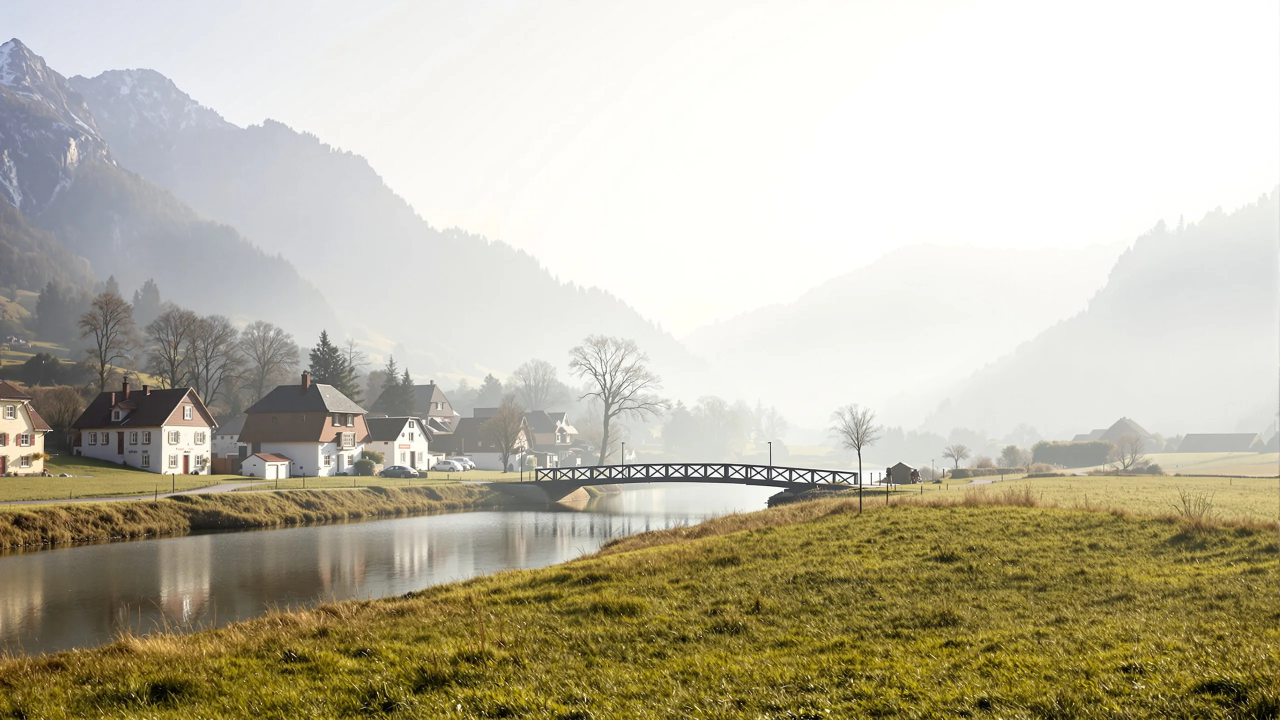 Kleine Fussgängerbrücke über einen ruhigen Fluss zwischen zwei Dörfern im Morgenlicht